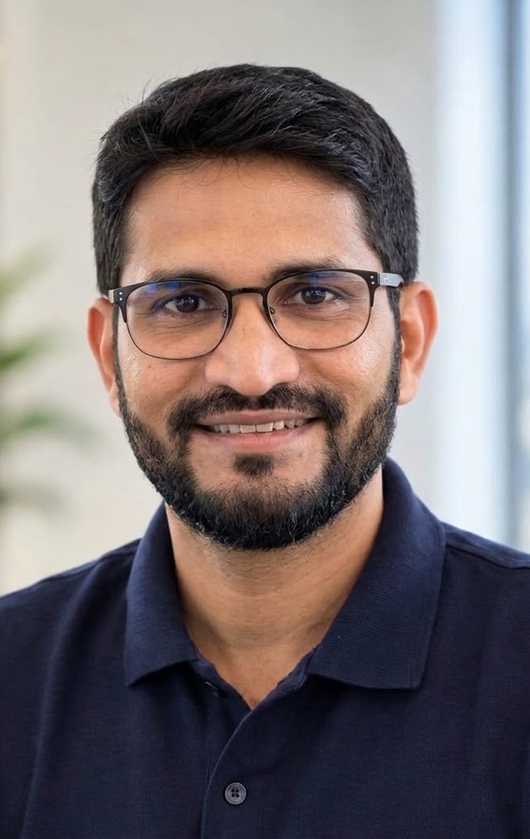 Riham Moin, Registered Investment Advisor, smiling in a dark suit and glasses